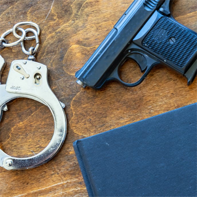 Handcuffs and a gun set on a desk