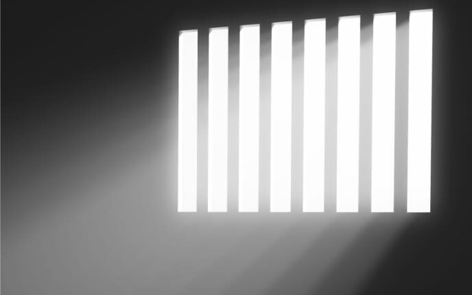 Light shining through barred window in a dark room